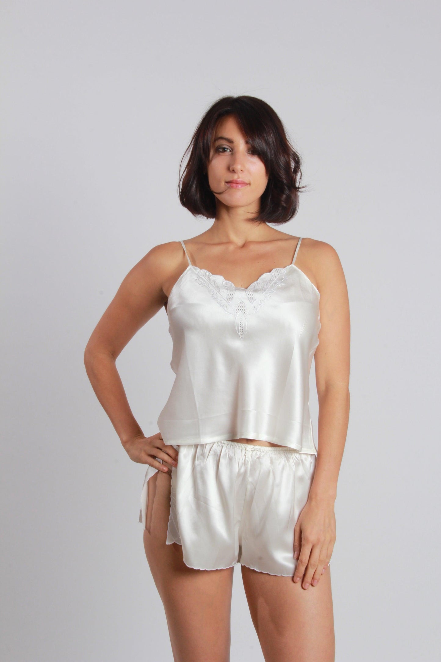 Including a camisole and a matching Frenchmen, this sweet two-piece silk lingerie set features pure high-quality satin silk, delicate handmade embroidery along neckline and hemline of camisole, the front lower left corner of panty and fantastic comfy cool; side slits on the hem of panty make it sweet and flirty.